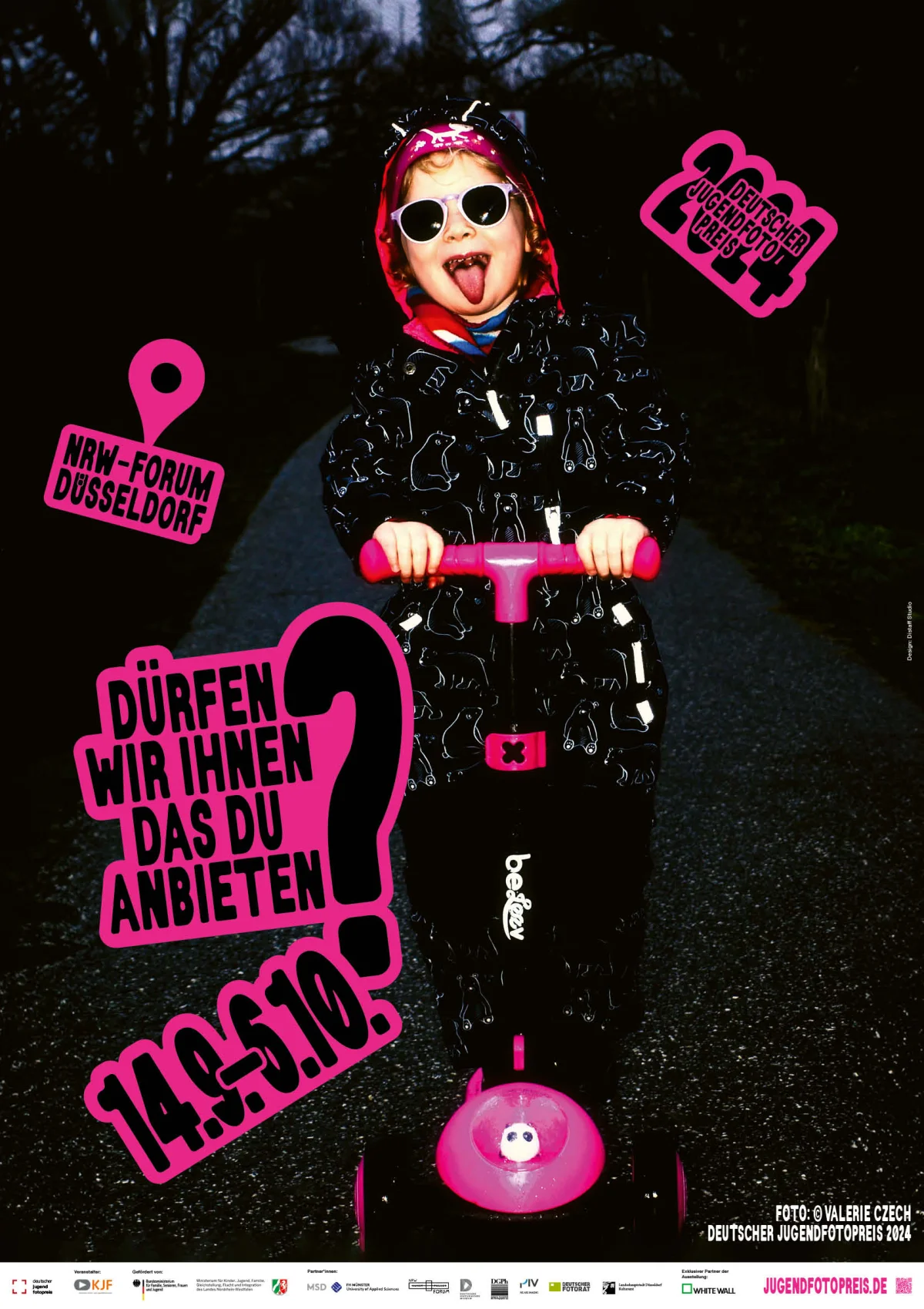 A child wearing a headscarf and round sunglasses sticks out their tongue on a scooter, with pink lettering over the photograph.