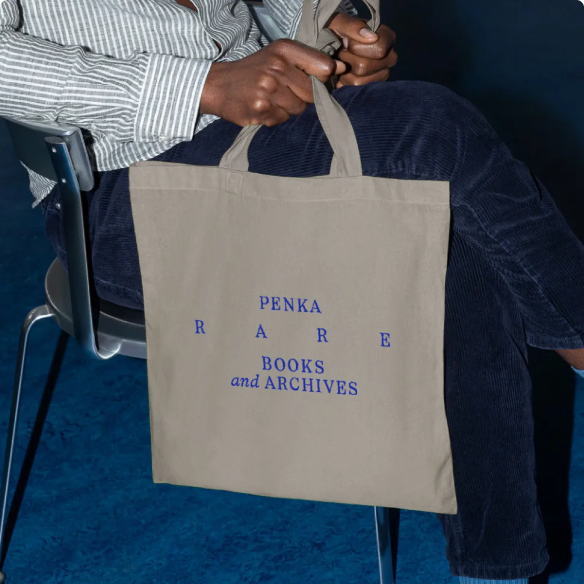 Eine sitzende Person hält einen grauen Stoffbeutel mit blauer PENKA-Wortmarke und weit gesperrtem „RARE“.