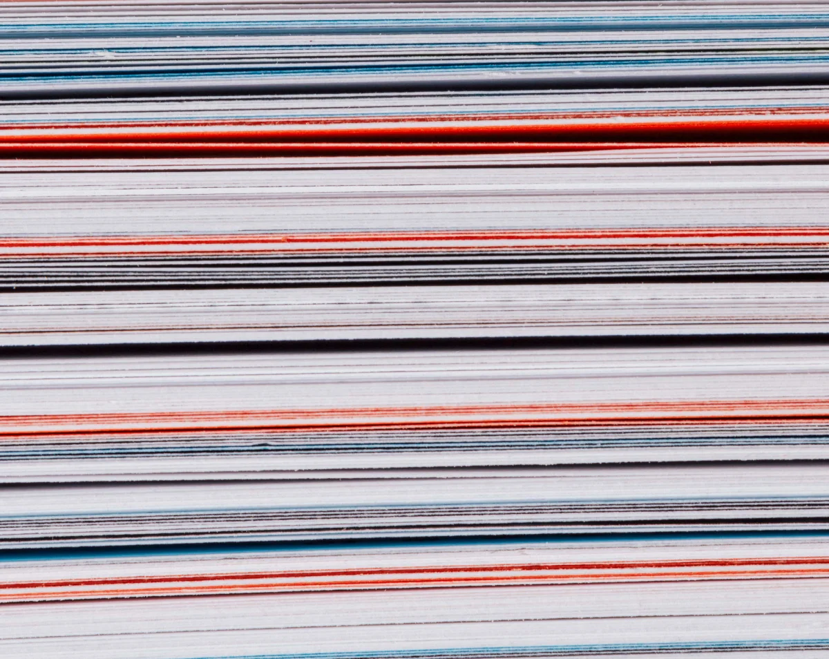 Side view of the “Specology” book block, with closely layered white, turquoise and orange pages.