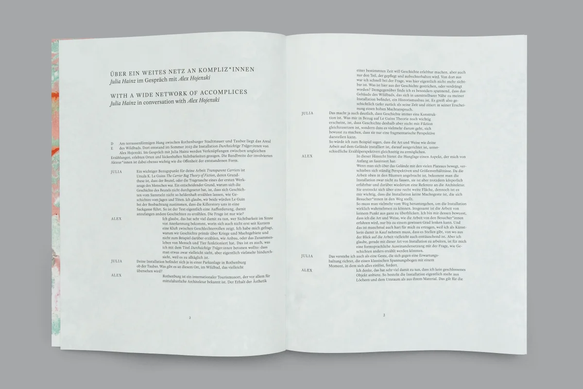 White book spread with a German and English interview arranged in narrow, offset text columns.